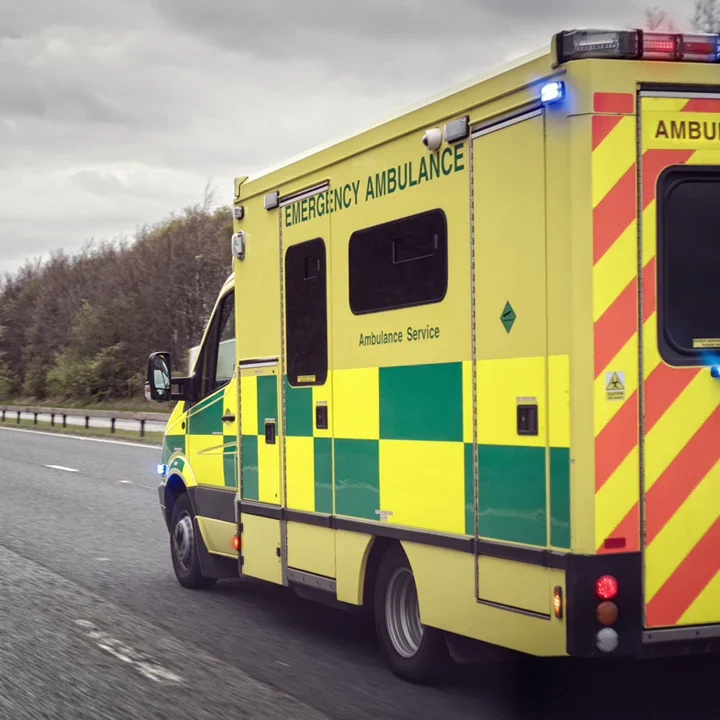 Emergency ambulance on the roadside with flashing lights.